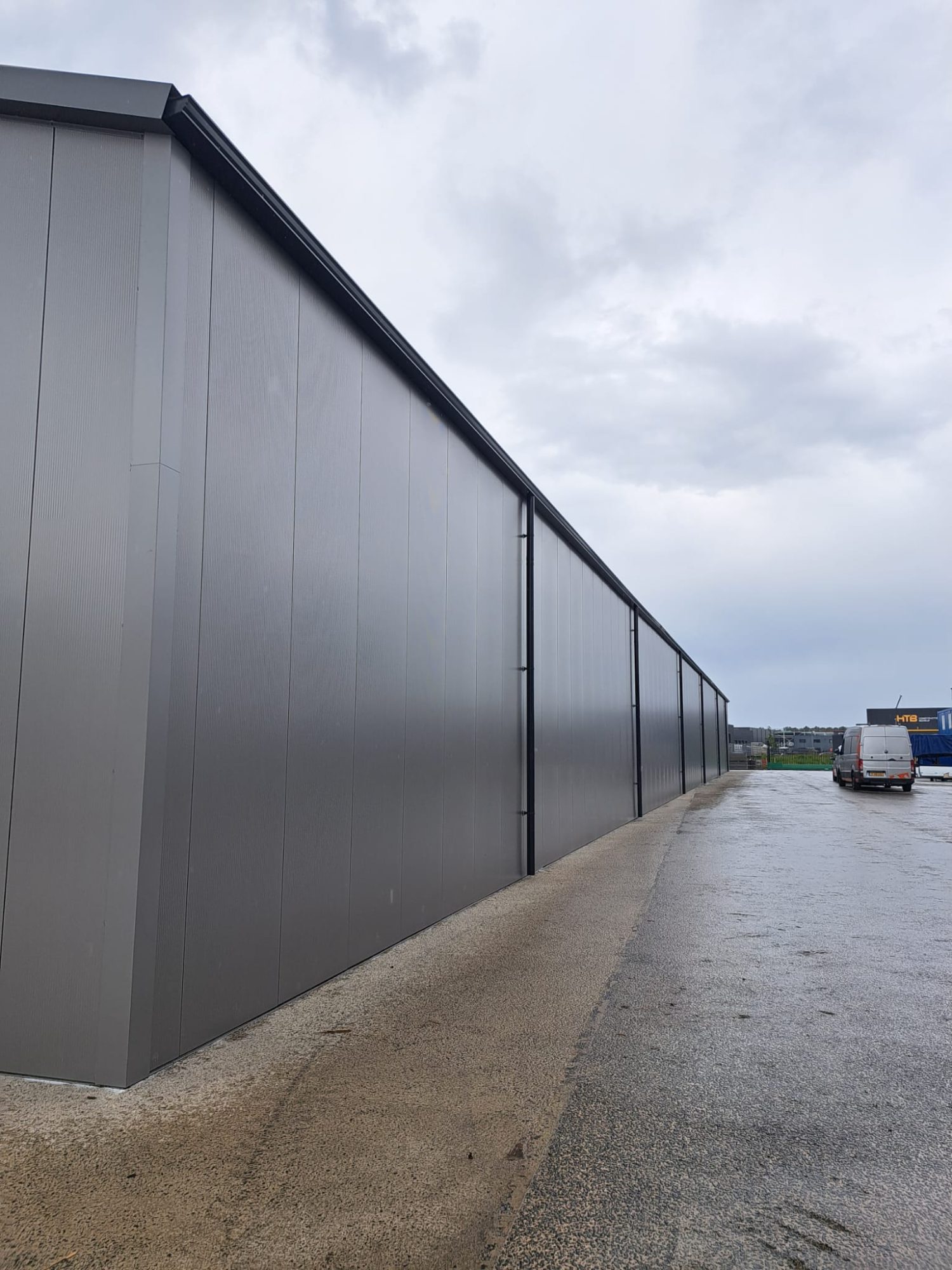 Aluminium dakgoot op een lange antraciete loods